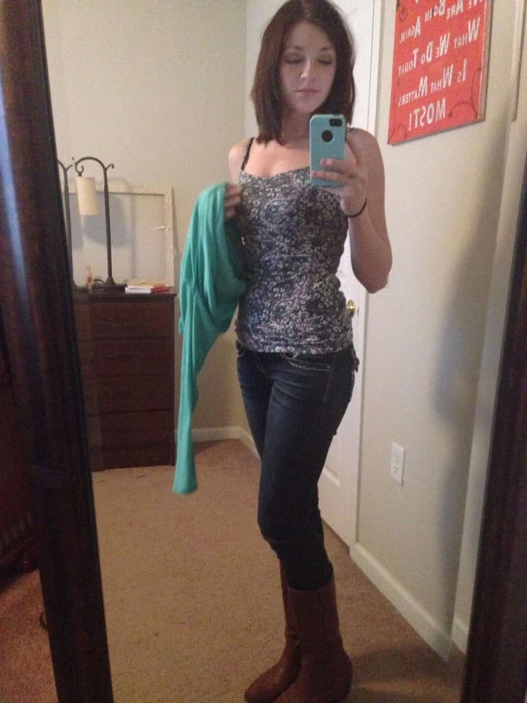 une teen sexy se fait des selfies dans sa chambre à moitié nue