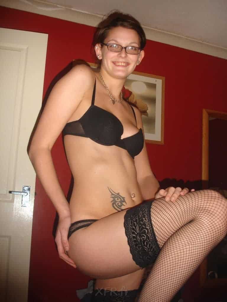 brunette coquine à lunettes aime jouer avec l'objectif pour ses photos hot