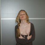 une blonde sexy relève son haut pour charmer